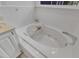 Close-up of a relaxing soaking tub in an all-white bathroom with window and bath caddy at 1913 Wild Dunes Dr, Raleigh, NC 27604