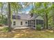 Rear exterior of home with wood deck, screened in porch and mature shade trees at 1913 Wild Dunes Dr, Raleigh, NC 27604