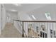 Upstairs hallway featuring skylights, a view of the living room, and access to multiple rooms at 1913 Wild Dunes Dr, Raleigh, NC 27604