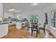 Bright kitchen featuring white cabinetry, a breakfast bar, and an adjacent dining area with wooded views at 1913 Wild Dunes Dr, Raleigh, NC 27604