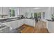Well lit kitchen with white cabinets, dark counters, hardwood floors, and backyard views at 1913 Wild Dunes Dr, Raleigh, NC 27604