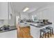 Eat in kitchen featuring white cabinets, dark countertops, and hardwood floors at 1913 Wild Dunes Dr, Raleigh, NC 27604