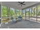 Relaxing screened-in porch with two chairs and side table, and views to the wooded backyard at 1913 Wild Dunes Dr, Raleigh, NC 27604