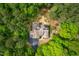 Aerial view of the home featuring a wooded lot, solar panels, and a circular driveway at 201 Summergate Cir, Chapel Hill, NC 27516