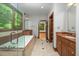 Bathroom features a large window with garden view, tub with shower and a granite countertop sink at 201 Summergate Cir, Chapel Hill, NC 27516