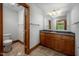 Bathroom vanity featuring dark cabinets, tile floors, and a framed mirror with decorative lights at 201 Summergate Cir, Chapel Hill, NC 27516