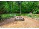 A stone fire pit is surrounded by pea gravel in the backyard of this wooded lot home at 201 Summergate Cir, Chapel Hill, NC 27516