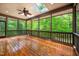 Screened patio with wood floors and ceiling fan overlooking lush greenery at 201 Summergate Cir, Chapel Hill, NC 27516