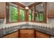Kitchen corner showcasing a stainless steel sink with granite countertops and wood trim windows at 201 Summergate Cir, Chapel Hill, NC 27516