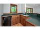 Basement wet bar featuring stained wood cabinetry, laminate countertops, and natural light at 201 Summergate Cir, Chapel Hill, NC 27516