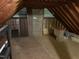 An unfinished attic shows wood floors, cinder block, exposed insulation, and some stored items at 202 Selkirk Pl, Durham, NC 27707