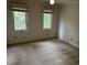 An empty carpeted bedroom shows two windows looking out into the trees at 202 Selkirk Pl, Durham, NC 27707