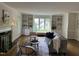 Comfortable living room with built-in bookshelves, a fireplace, and large windows at 202 Selkirk Pl, Durham, NC 27707