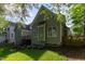 Back exterior of a charming home featuring green siding and a manicured backyard surrounded by mature trees at 216 Billingrath Turn Ln, Cary, NC 27519