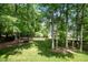 Lush backyard featuring a healthy lawn, mature trees, and a wooden fence at 216 Billingrath Turn Ln, Cary, NC 27519