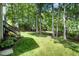 Well-maintained backyard featuring a lush green lawn, mature trees, and landscape features at 216 Billingrath Turn Ln, Cary, NC 27519