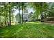 Spacious yard featuring lush greenery, mature trees, and the home's rear exterior at 216 Billingrath Turn Ln, Cary, NC 27519