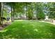 Large backyard featuring healthy lawn, mature trees, a partially obscured home and a fence at 216 Billingrath Turn Ln, Cary, NC 27519