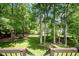 Tranquil backyard with green lawn, mature trees, wooden fence and a view from the deck at 216 Billingrath Turn Ln, Cary, NC 27519