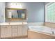 Bathroom with a double vanity, large mirror, and jacuzzi bathtub at 216 Billingrath Turn Ln, Cary, NC 27519