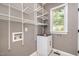 Bright laundry room featuring white wire shelving, storage cabinet, and a view from the window at 216 Billingrath Turn Ln, Cary, NC 27519