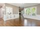 Bright living room features hardwood floors, wainscoting, and French doors at 216 Billingrath Turn Ln, Cary, NC 27519