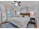 Bright bedroom features a ceiling fan, hardwood floors and soft natural light from the large windows at 2442 Stevens Rd, Raleigh, NC 27610