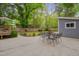 Backyard patio with outdoor dining set, mature trees and landscaping at 2442 Stevens Rd, Raleigh, NC 27610