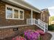 Brick home showcasing a quaint front porch with a small garden, enhancing curb appeal at 2581 Green Valley Blvd, Burlington, NC 27217
