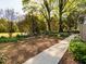 Landscaped front yard featuring a variety of trees, plants and concrete walkways to the home at 2581 Green Valley Blvd, Burlington, NC 27217