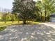 Spacious front yard with a mature tree, expansive driveway, and well-maintained lawn at 2581 Green Valley Blvd, Burlington, NC 27217