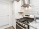 Close-up of the kitchen stove with a stainless steel vent hood and granite countertops at 2581 Green Valley Blvd, Burlington, NC 27217