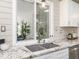 Kitchen counter with window looking out onto a covered patio and grey farmhouse sink at 2581 Green Valley Blvd, Burlington, NC 27217