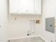 Bright laundry room with white cabinets and tile flooring, offering a clean and functional space at 2581 Green Valley Blvd, Burlington, NC 27217