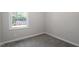 Bright bedroom with a window offering natural light and neutral colored walls and gray carpet at 2612 Glenbrook Dr, Durham, NC 27704