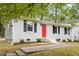 Charming home with white painted brick, dark shutters, red front door, and fresh landscaping at 2612 Glenbrook Dr, Durham, NC 27704