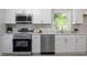 Modern kitchen featuring stainless steel appliances, a dishwasher, and sleek white cabinets at 2612 Glenbrook Dr, Durham, NC 27704
