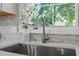 Close-up of a modern kitchen sink with a stainless steel faucet and decorative backsplash at 2612 Glenbrook Dr, Durham, NC 27704