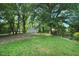 Large, grassy backyard with mature trees and a detached two-car garage provides ample space at 2709 Farthing St, Durham, NC 27704