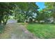 Large backyard with mature trees, grass, and a detached two car garage at 2709 Farthing St, Durham, NC 27704