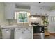 Bright kitchen featuring white cabinets, stainless steel appliances, and a large window at 2709 Farthing St, Durham, NC 27704