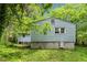 Exterior side of the home featuring light blue siding and basement access at 2733 Thelma St, Durham, NC 27704