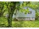 Exterior of the home featuring light blue siding and some mature trees at 2733 Thelma St, Durham, NC 27704