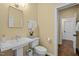 A well-lit bathroom showcases a pedestal sink, commode, and view into the hallway at 2908 Stubble Field Dr, Raleigh, NC 27613