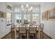 Bright dining room with large windows, hardwood floors, and contemporary chandelier above a glass table at 2908 Stubble Field Dr, Raleigh, NC 27613