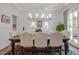 Classic dining room featuring a wooden table, upholstered chairs, paneled walls, and elegant lighting at 2908 Stubble Field Dr, Raleigh, NC 27613