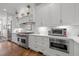 Modern kitchen featuring white cabinetry, stainless steel appliances, and beautiful hardwood floors at 2908 Stubble Field Dr, Raleigh, NC 27613