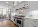 A modern kitchen with stainless steel appliances, white cabinetry, and a view of the dining area at 2908 Stubble Field Dr, Raleigh, NC 27613