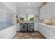 Light and bright laundry room featuring modern appliances, custom cabinets, and a pet shower at 2908 Stubble Field Dr, Raleigh, NC 27613