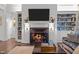 Living room featuring fireplace, built-in bookshelves, modern lighting and hardwood floors at 2908 Stubble Field Dr, Raleigh, NC 27613